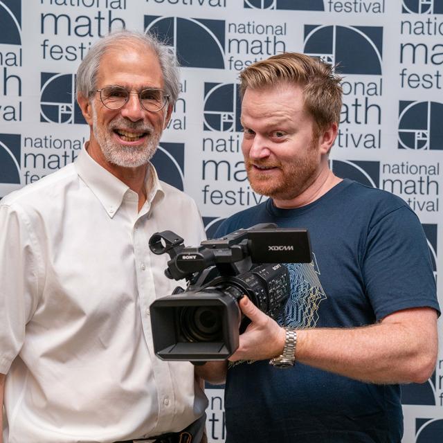 Numberphile's Brady Haran with camera and MSRI's David Eisenbud at National Math Festival 2019