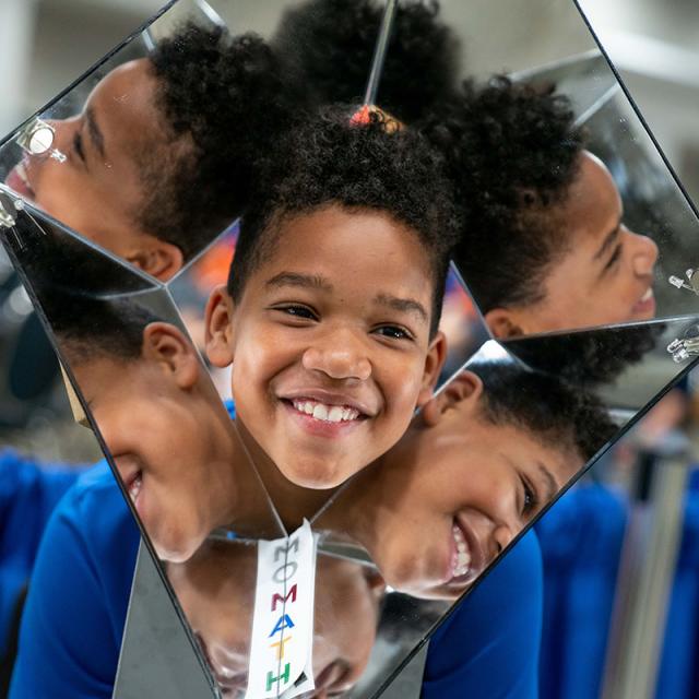 boy smiling with mirror toy at 2019 festival