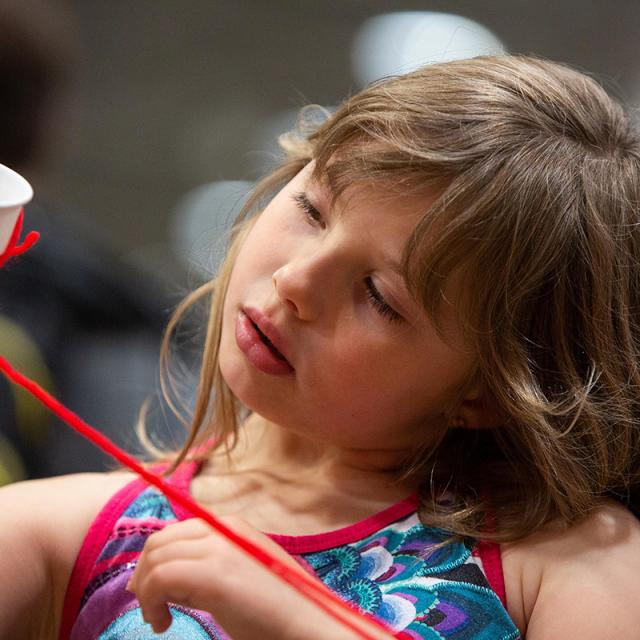 Girl holding cup and string at 2019 festival
