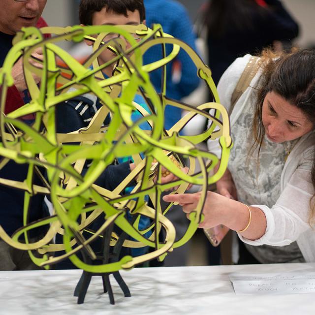 Woman examining sculpture at 2019 Festival Math-Art Exhibit
