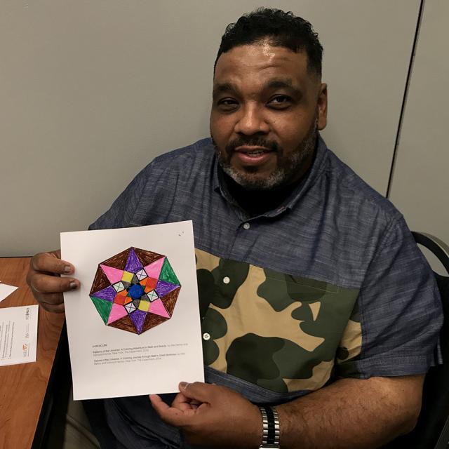 Man holding mathematical coloring page - National Math Festival 2019