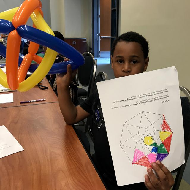 Boy holding mathematical coloring page and balloon Sculpture - National Math Festival 2019