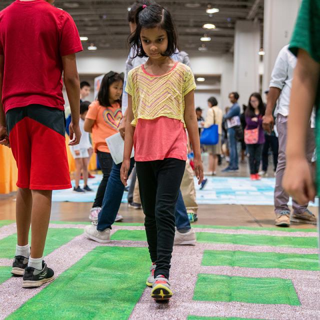 Girl walking on activity mat at 2019 festival