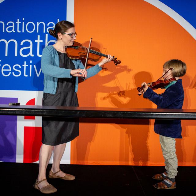 2019 festival presenter Lillian Pierce plays violin with young event attendee