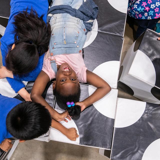 2019 Event attendees laying on large play blocks
