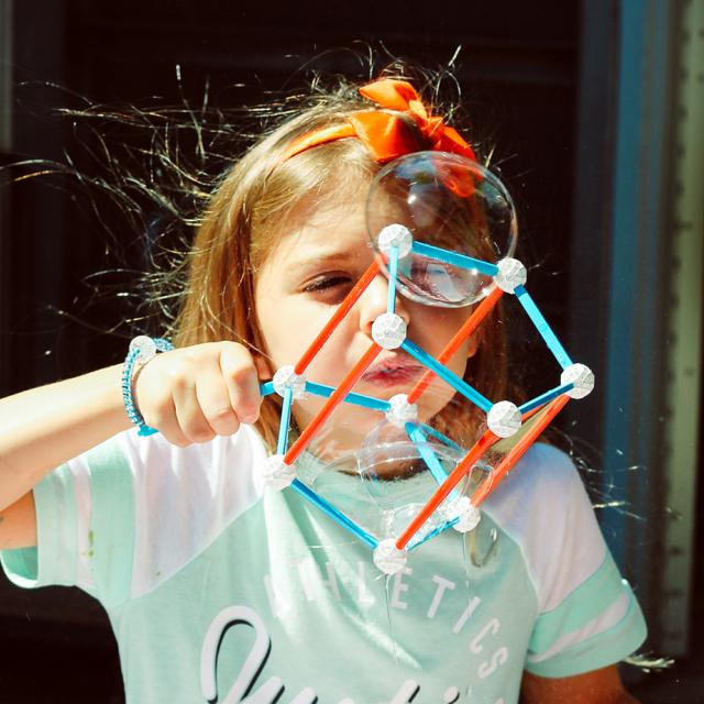 girl playing with bubble shapes